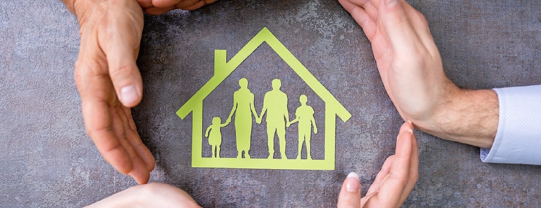 Hands surround image of a house with people inside